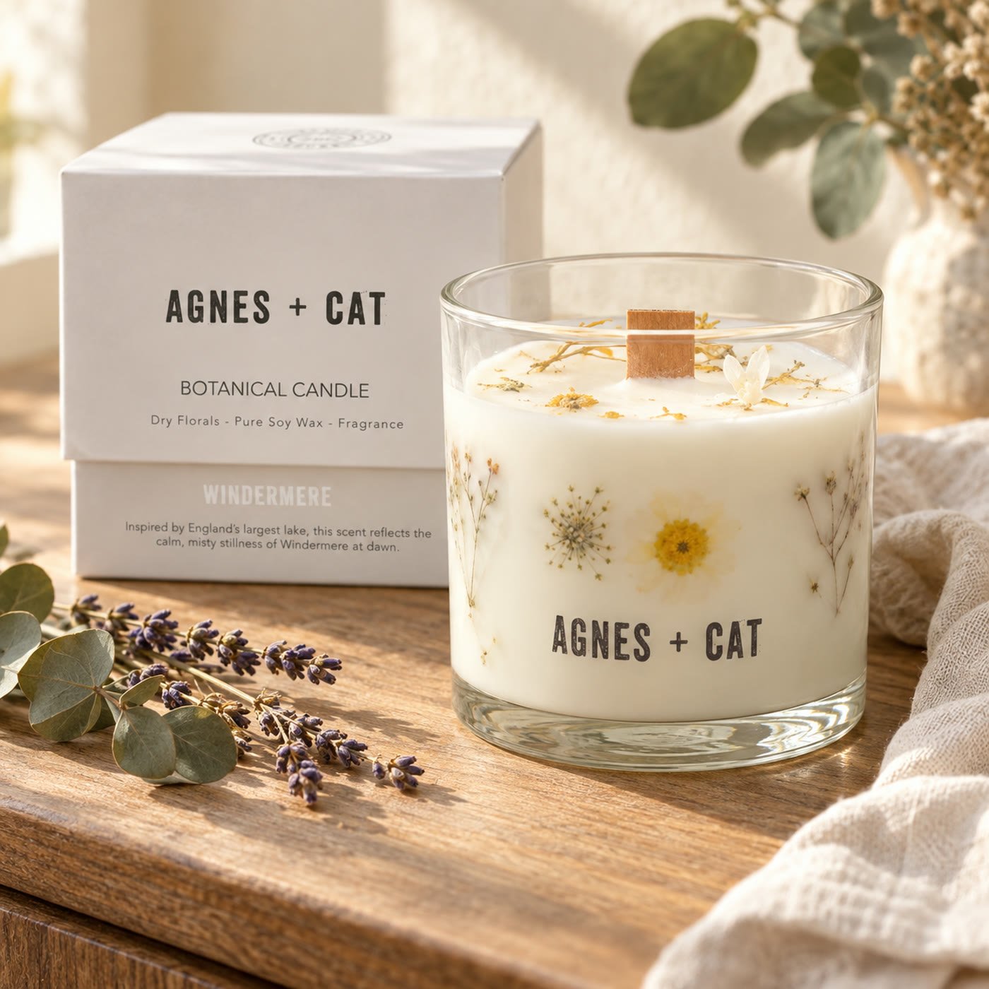 Vela botânica Agnes+Cat com flores secas na cera e caixa Windermere num aparador de madeira com lavanda