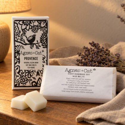 Ceras de soja Agnes+Cat Provence com o embrulho e duas pastilhas numa mesa ao fim do dia, com lavanda seca